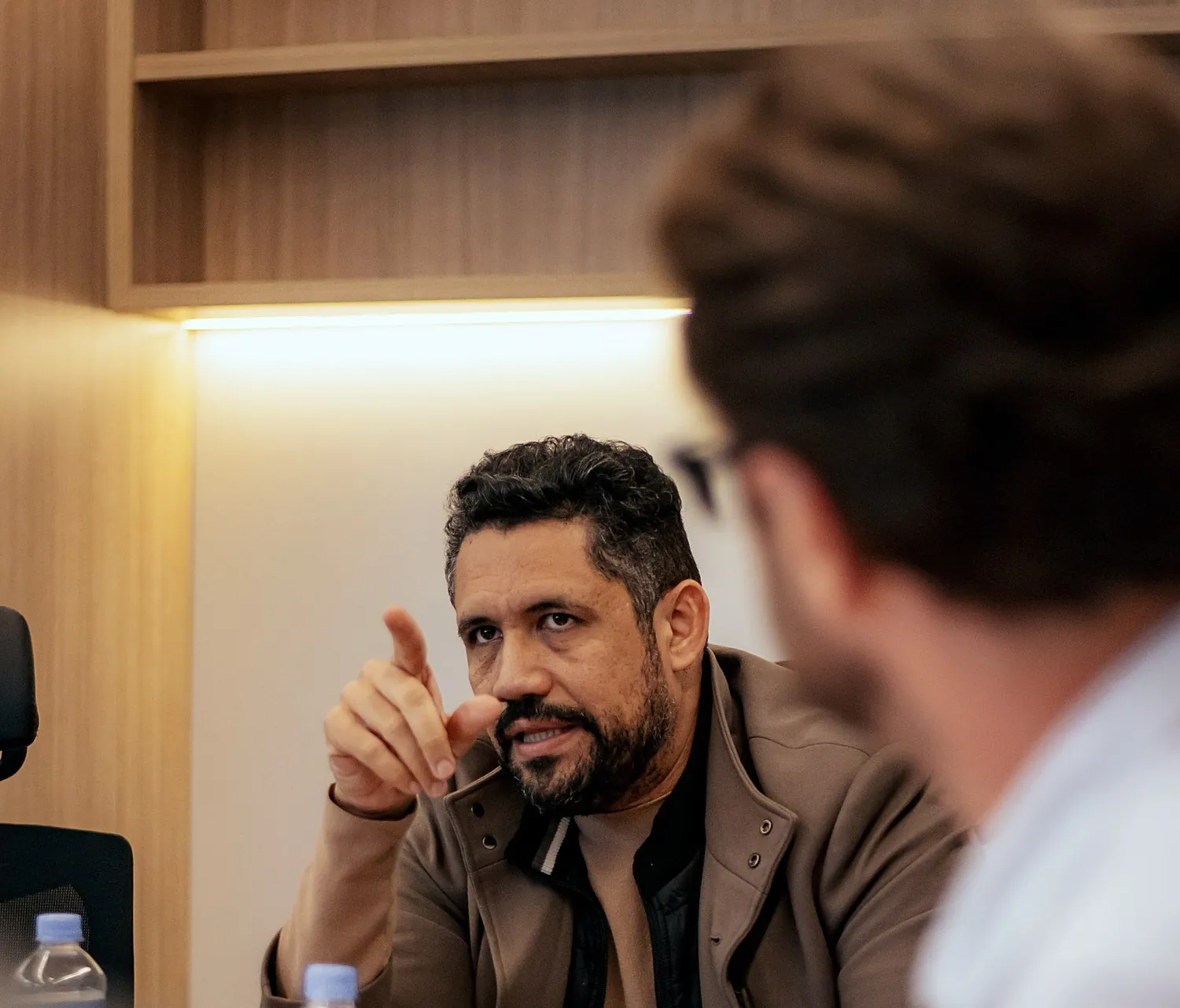 Vagner Campos sentado à mesa, apontando enquanto argumenta com os conselheiros em formação