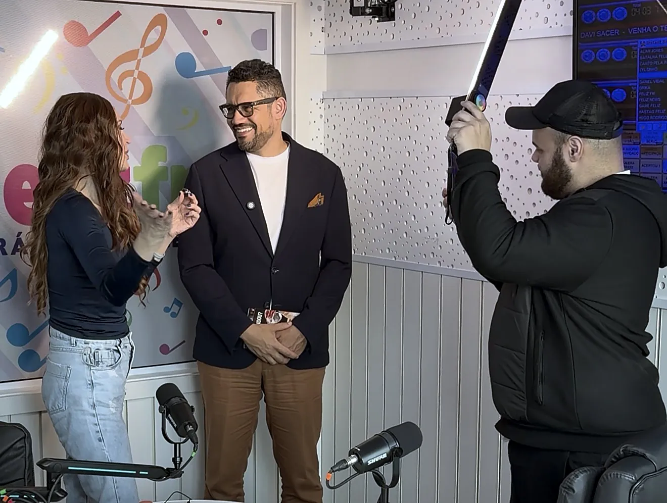 Vagner Campos sendo entrevistado e filmado no estúdio da Feliz FM