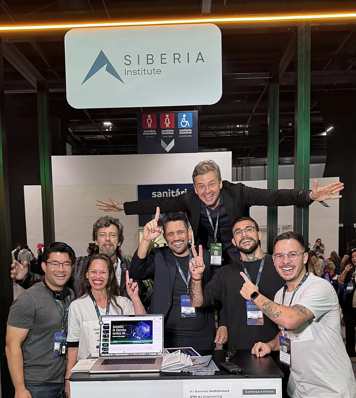 Vagner Campos e grupo comemorando no estande do Siberia Institute no AI Brasil Experience 2025
