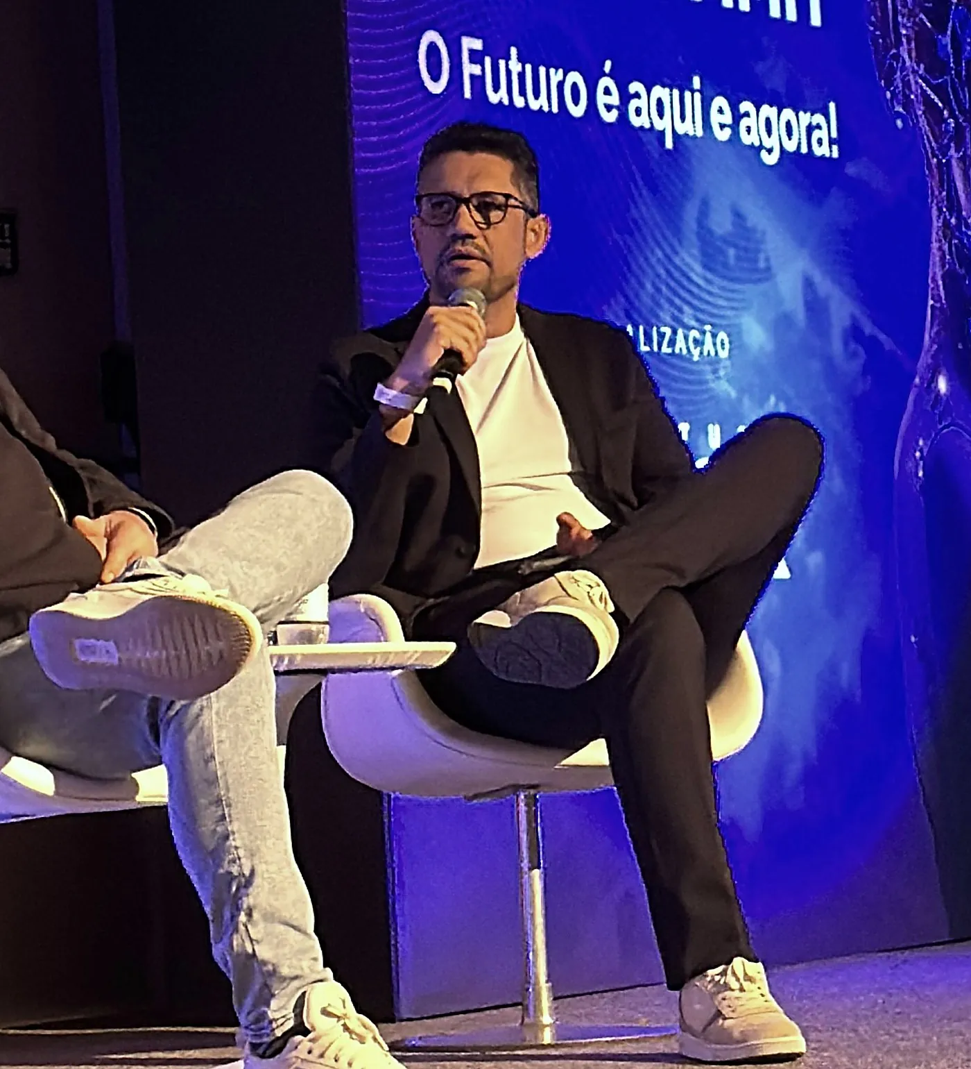 Vagner Campos falando ao microfone em painel do AI Summit Brasil 2025