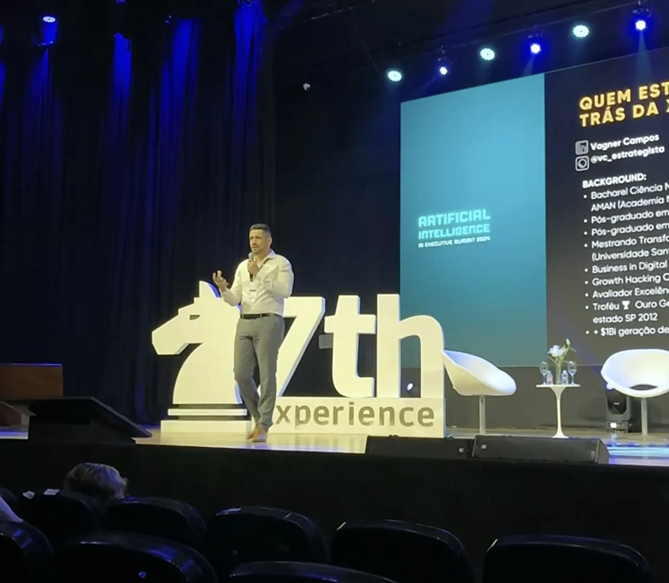 Vagner Campos falando ao microfone no palco do 7th Experience, AI Executive Summit 2024