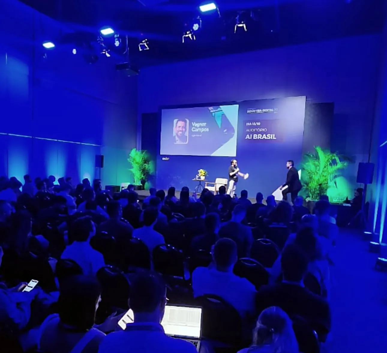 Auditório AI Brasil lotado no E-Commerce Brasil Indústria Digital, com o nome de Vagner Campos no telão