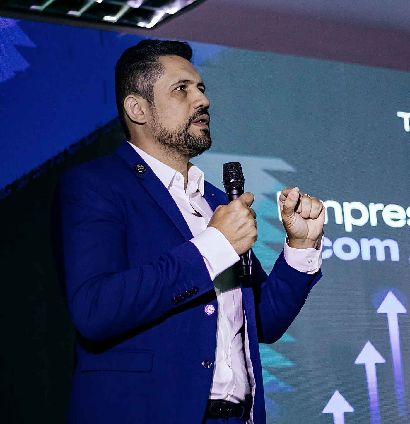 Vagner Campos de terno azul, ao microfone, em palestra no Moveday em Santa Catarina