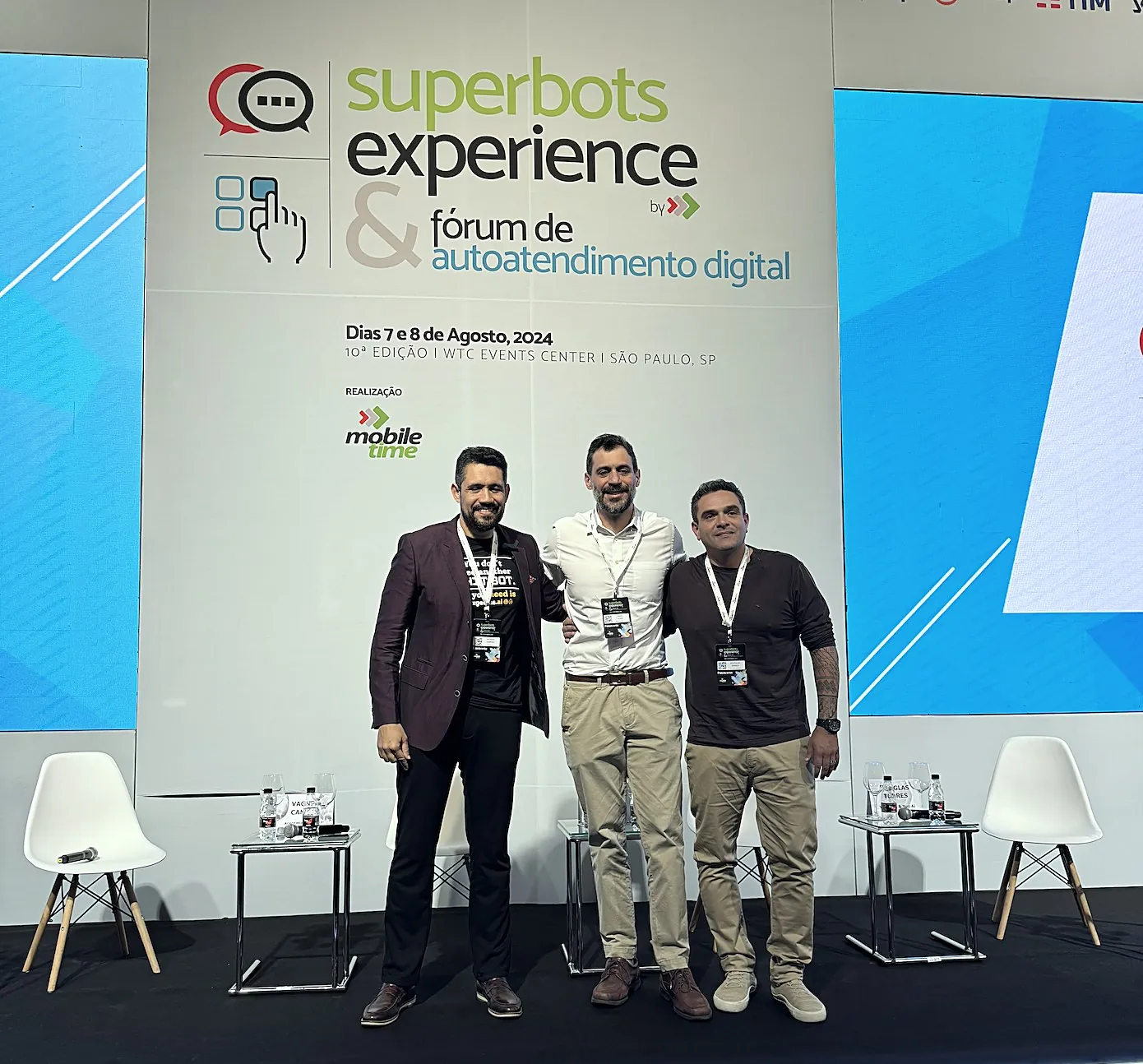Vagner Campos com dois participantes no palco do Super Bots Experience, em São Paulo