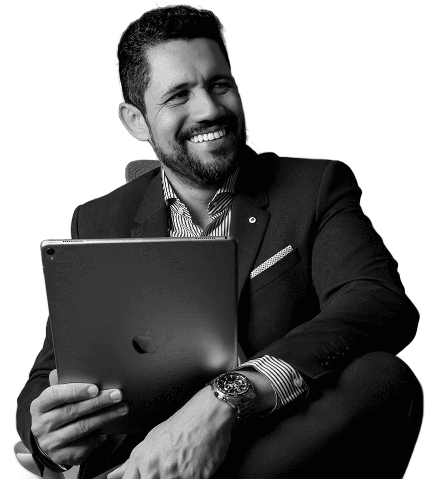 Vagner Campos sorrindo, com um tablet nas mãos, em fotografia em preto e branco