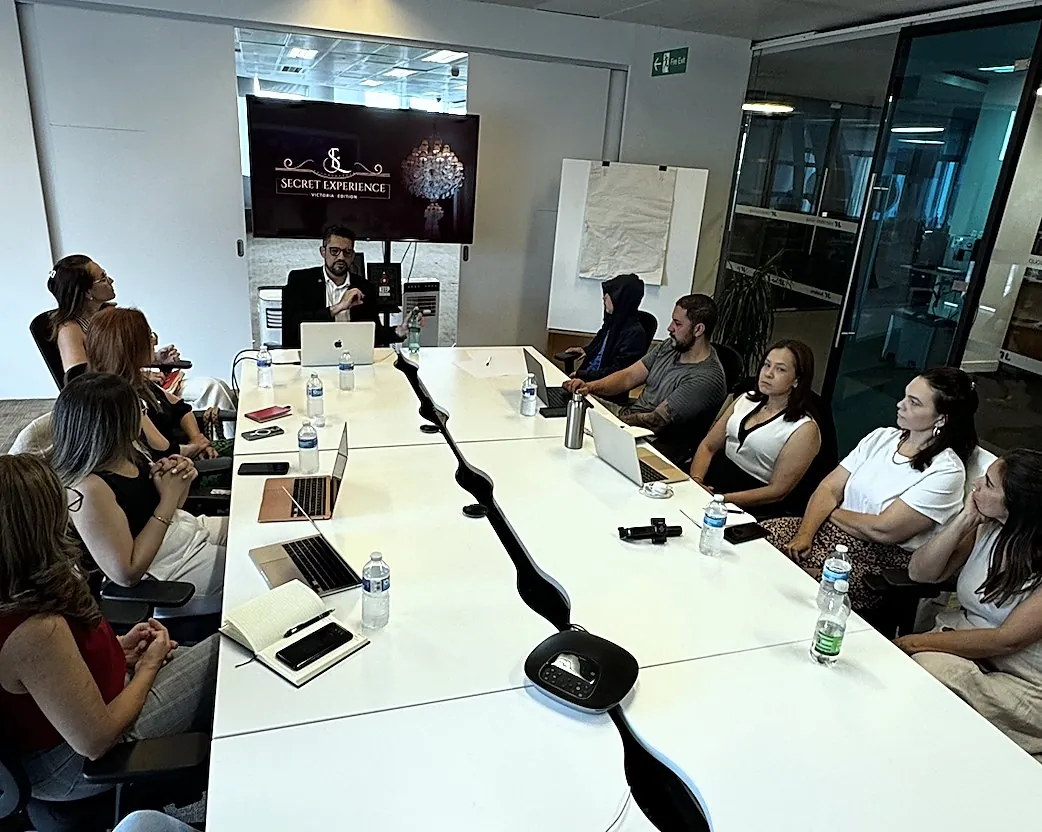 Sala de reunião em Londres com participantes em volta da mesa e Vagner Campos à cabeceira